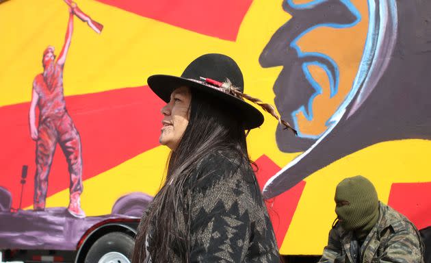 Kanahus Manuel, a member of the Tiny House Warriors, sits in front of a tiny home located in the Tiny House Warriors village in Blue River, B.C. (Photo: Aaron Hemens for HuffPost)