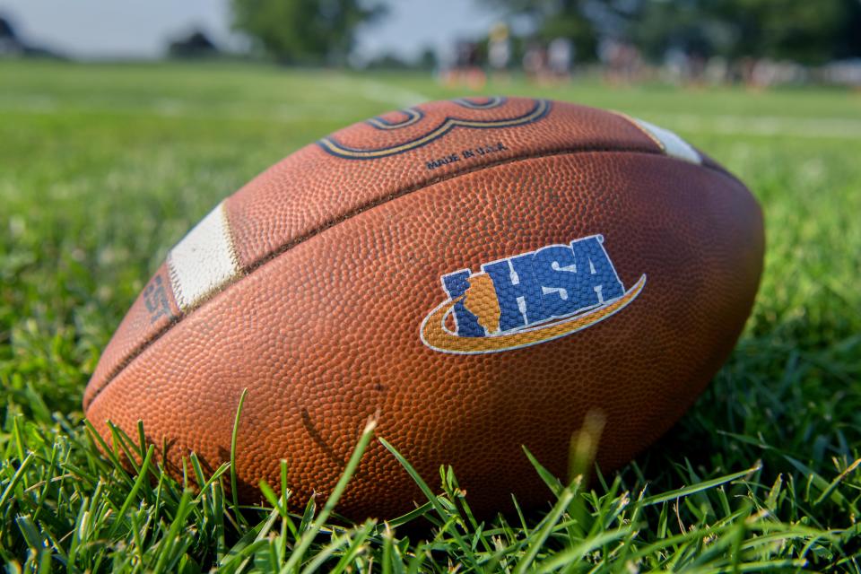 The IHSA logo is emblazoned on a football lying on the practice field on the official first day of high school football practice Monday, Aug. 7, 2023.