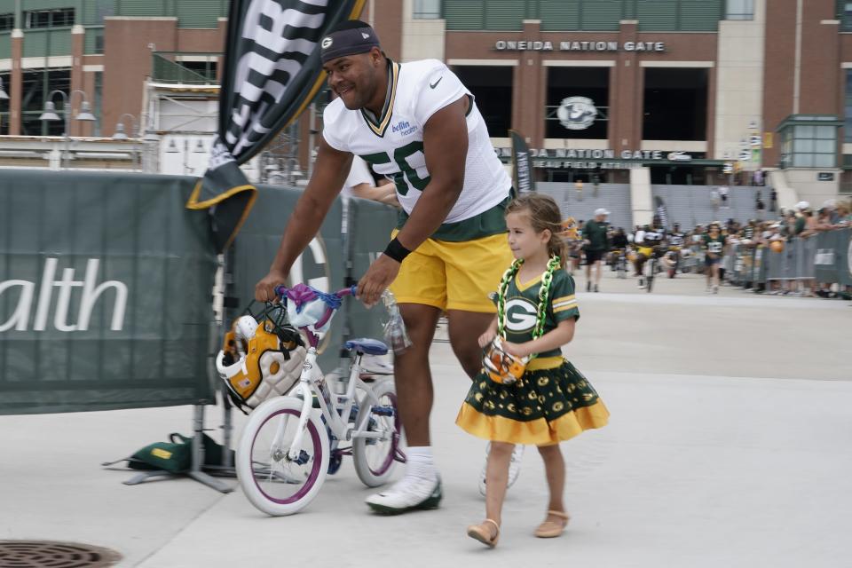 Green Bay Packers' Zach Tom walks a bike to the NFL football team's practice field Wednesday, July 27, 2022, in Green Bay, Wis. (AP Photo/Morry Gash)