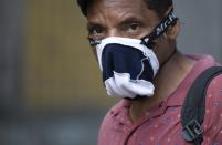 A pedestrian wears a home made mask as a precaution amid the spread of the new coronavirus in Caracas, Venezuela, Thursday, April 2, 2020. (AP Photo/Ariana Cubillos)