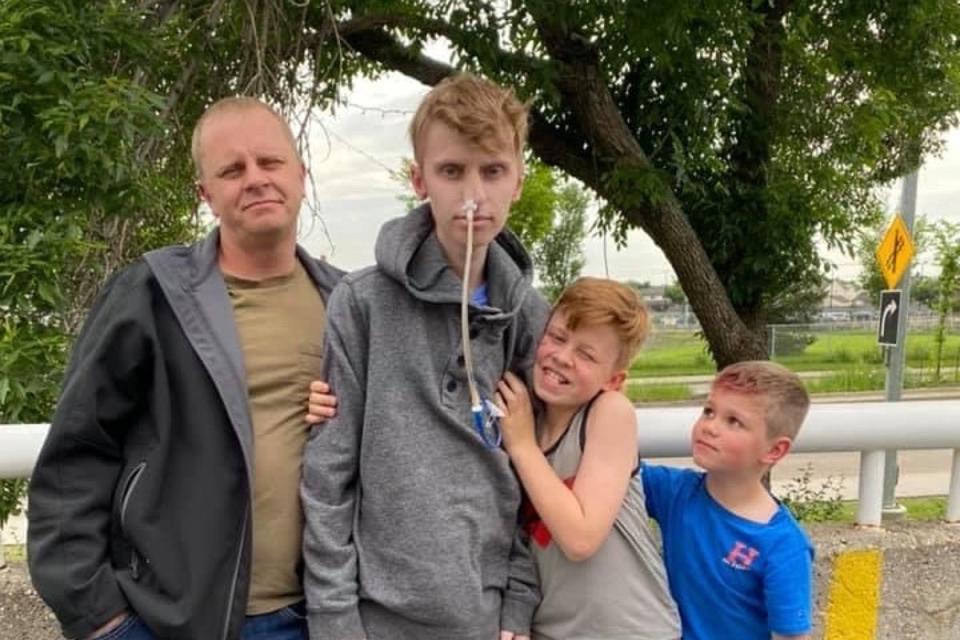 Eric, second left, poses with his father, Wade Coulam, left, and his two younger brothers (GoFundMe)