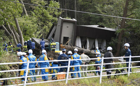 Police officers and rescue workers search for survivors from a building damaged by a landslide caused by a powerful earthquake in Atsuma town in Japan's northern island of Hokkaido, Japan, in this photo taken by Kyodo September 6, 2018. Mandatory credit Kyodo/via REUTERS