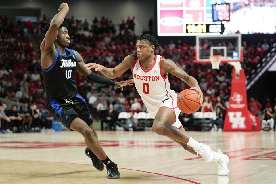 Houston guard Marcus Sasser (0) dribbles the ball as Tulsa forward Tim Dalger defends during the second half of an NCAA college basketball game Wednesday, Feb. 8, 2023, in Houston. (AP Photo/Eric Christian Smith)