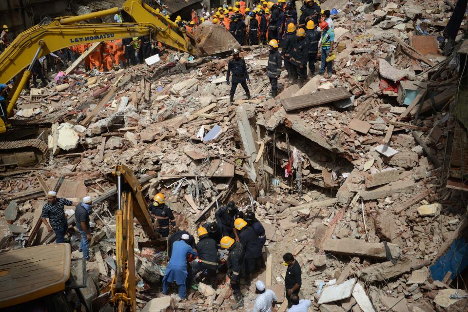 <p>Indian rescue workers look for survivors in the debris of a collapsed building in Mumbai on Aug. 31, 2017. (Photo: Punit Paranjpe/AFP/Getty Images) </p>