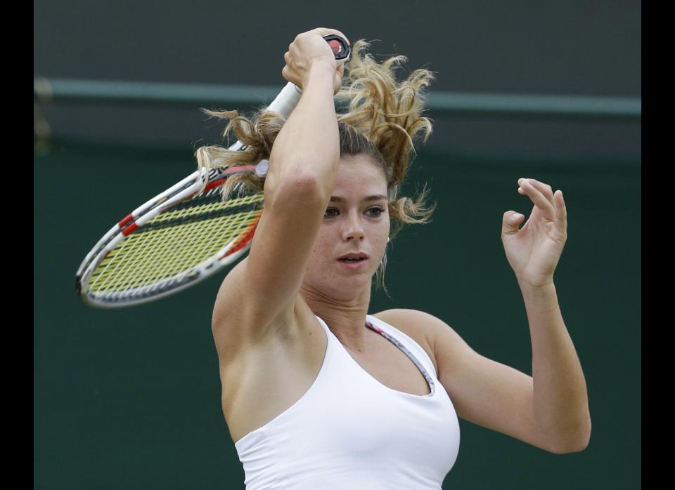 Camila Giorgi of Italy returns a shot to Nadia Petrova of Russia during a third round women's singles match at the All England Lawn Tennis Championships at Wimbledon, England, Friday, June 29, 2012.