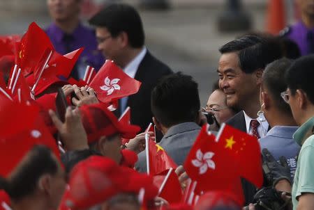 Hong Kong Chief Executive Leung Chun-ying (3rd R) greets onlookers waving China and Hong Kong flags at a flag raising ceremony in Hong Kong October 1, 2014, celebrating the 65th anniversary of China National Day. REUTERS/Bobby Yip