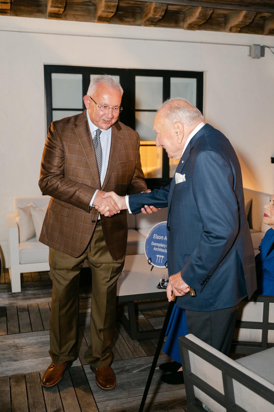 On a rooftop terrace at the White Elephant Palm Beach, Khalid Hashem, president of White Elephant Resorts, left, shakes hands with the Hon. Edward Elson, a former U.S. ambassador to Denmark, during a Nov. 5 presentation of the inaugural Edward E. and Suzanne G. Elson Award, which recognized the restoration-and-renovation project at the landmarked hotel.