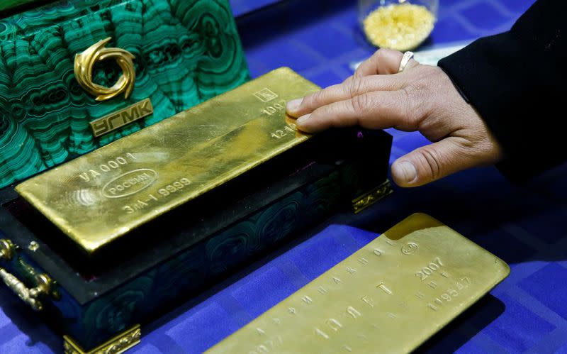 FILE PHOTO: Employee displays a gold bar at a gold refining workshop of the plant of Uralelektromed Joint Stock Company, the enterprise of Ural Mining and Metallurgical company in the town of Verkhnyaya Pyshma