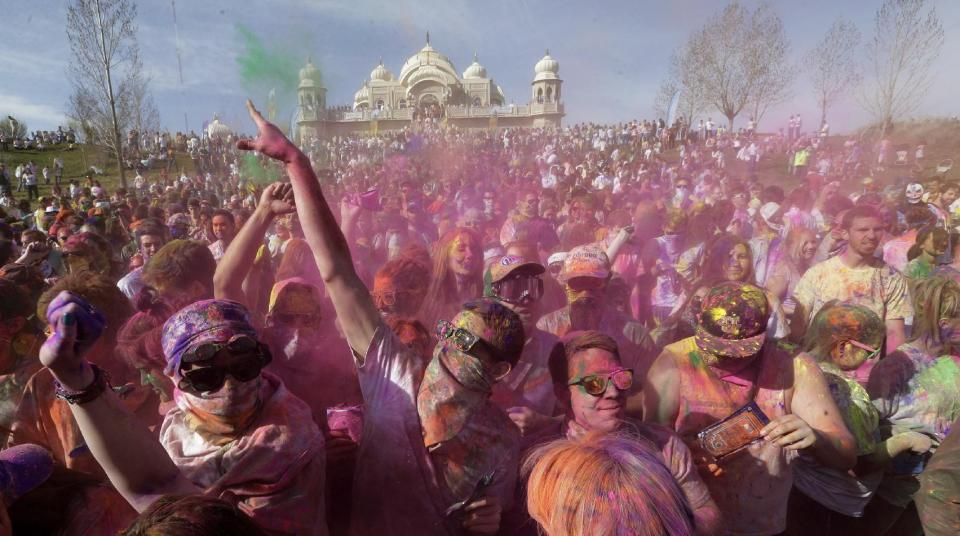 Revelers covered in colored corn starch celebrate during the 2014 Festival of Colors, Holi Celebration at the Krishna Temple Saturday, March 29, 2014, in Spanish Fork, Utah. Nearly 70,000 people are expected to gather starting Saturday at a Sri Sri Radha Krishna Temple in Spanish Fork for the annual two-day festival of colors. Revelers gyrate to music and partake in yoga during the all-day festival, throwing colored corn starch in the air once every hour. The Salt Lake Tribune reports that the large majority of participants are not Hindus, but Mormons. Thousands of students from nearby Brigham Young University come to take part in a festival that is drug and alcohol free. The event stems from a Hindu tradition celebrating the end of winter and the triumph of good over evil. (AP Photo/Rick Bowmer)