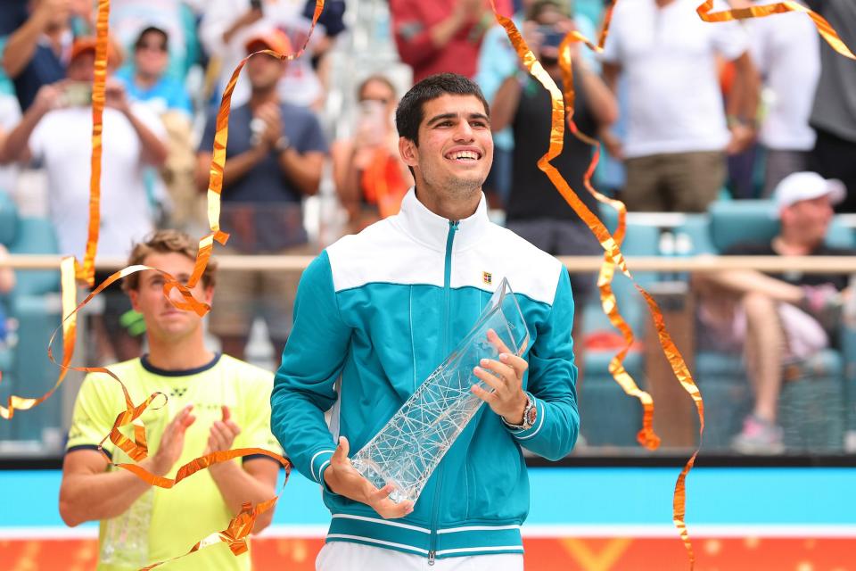 Carlos Alcaraz of Spain raises the Butch Buchholz Trophy after defeating Casper Ruud of Norway in the Men's Singles final during the Miami Open at Hard Rock Stadium