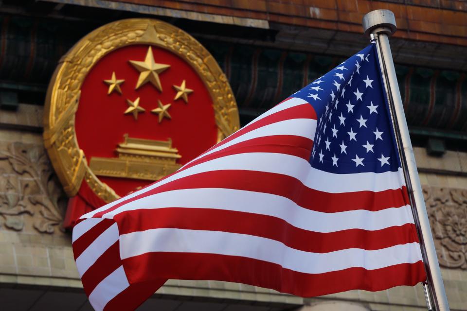 An American flag is flown next to the Chinese national emblem during a welcome ceremony at the Great Hall of the People in Beijing, Nov. 9, 2017.