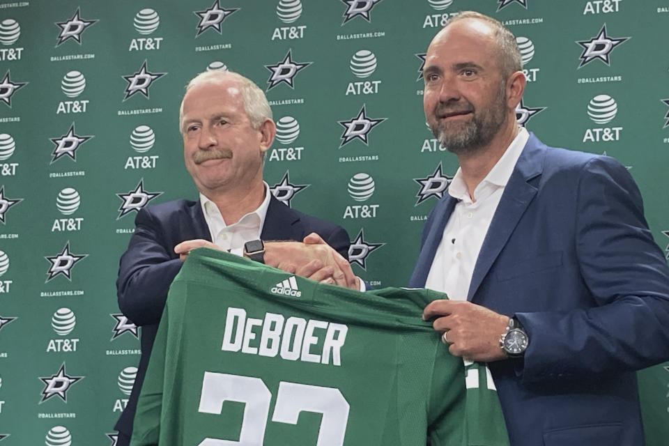 FILE - Dallas Stars NHL hockey team general manager Jim Nill, left, shakes hands with new coach Pete DeBoer during an introductory news conference in Dallas, June 22, 2022. Nill sensed things coming together for the Stars even before the season started with new coach Pete DeBoer and a roster mixed with proven veterans, up-and-coming young players and even a teenaged center. At the NHL’s All-Star break, after 51 games together, these Stars are leading the Western Conference. (AP Photo/Schuyler Dixon, file)