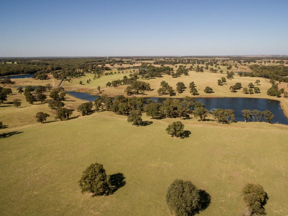 A view of a small lake amid rolling grass fields at Terry Bradshaw's ranch.