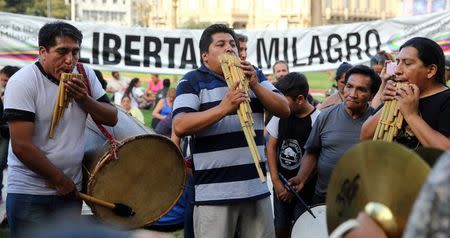 Supporters of Milagro Sala, the leader of the Tupac Amaru social welfare group, play instruments in front of a sign that reads "Free Milagro" as they gather to hear Sala's trial in San Salvador de Jujuy, with charges ranging from intimidation to corruption, on a radio outside a Justice building in Buenos Aires, Argentina, December 28, 2016. REUTERS/Marcos Brindicci