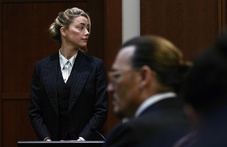 La actriz Amber Heard y el actor Jonny Depp ven al jurado llegar al Tribunal de Circuito del Condado de Fairfax en Fairfax, Virginia, el martes 17 de mayo de 2022. Depp demandó a Heard, su exesposa, por difamación, por un artículo de opinión publicado en 2018 en el Washington Post en el que ella se refirió a sí misma como una "figura pública que representa el abuso doméstico". (Brendan Smialowski/Pool photo via AP)