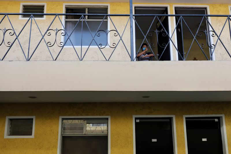 An unaccompanied minor who was deported from the U.S. sits at the entrance of his room at a shelter in Guatemala City