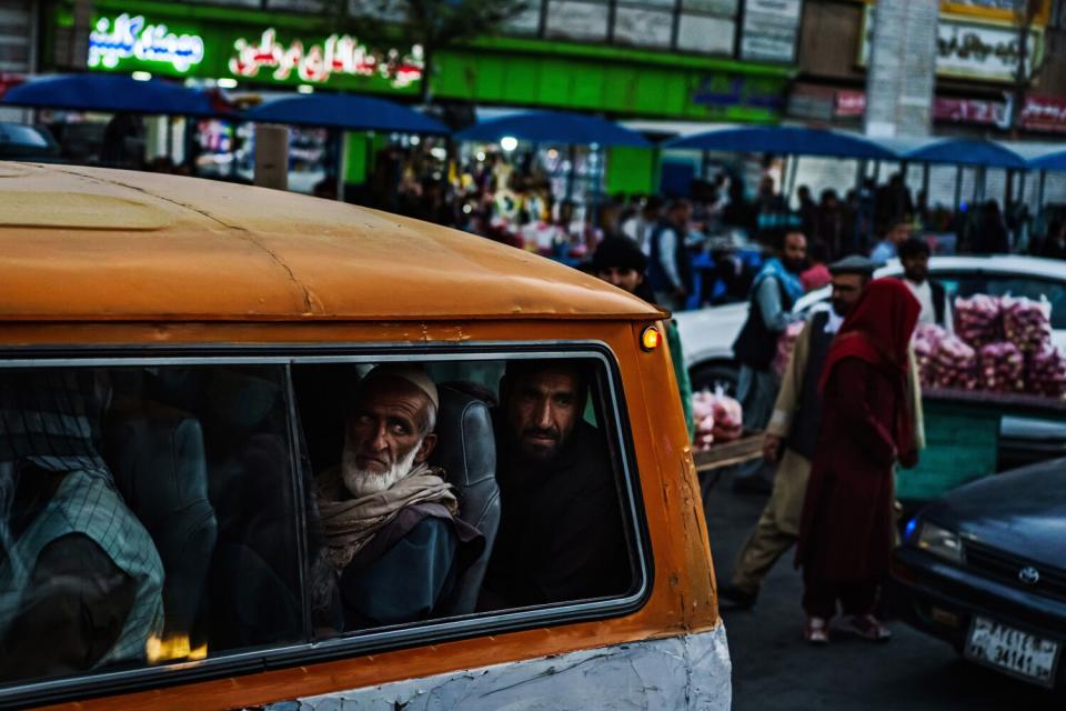 Men on a minibus look out the window.