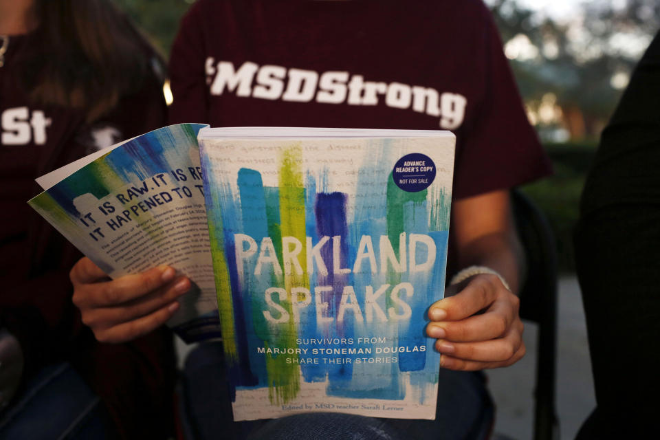 In this Wednesday, Jan. 16, 2019, photo, Leni Steinhardt, 16, reads from a new book called "Parkland Speaks: Survivors from Marjory Stoneman Douglas Share Their Stories," during an interview with The Associated Press, in Parkland, Fla. (AP Photo/Brynn Anderson)