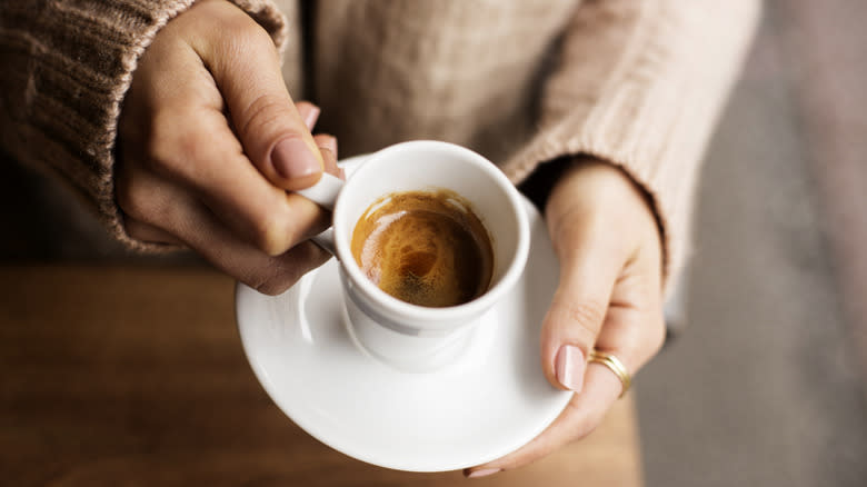 hands holding espresso cup