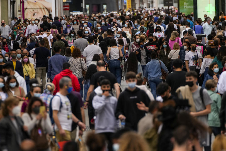 Decenas de personas con cubrebocas por el coronavirus caminan por una calle comercial en el centro de Madrid, España, el 5 de junio de 2021. (AP Foto/Manu Fernandez)