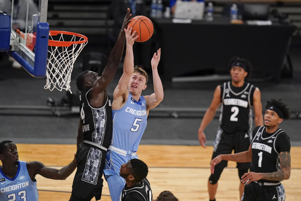 Georgetown's Chudier Bile (4) blocks a shot by Creighton's Alex O'Connell (5) during the second half of an NCAA college basketball game in the championship of the Big East Conference tournament Saturday, March 13, 2021, in New York. (AP Photo/Frank Franklin II)