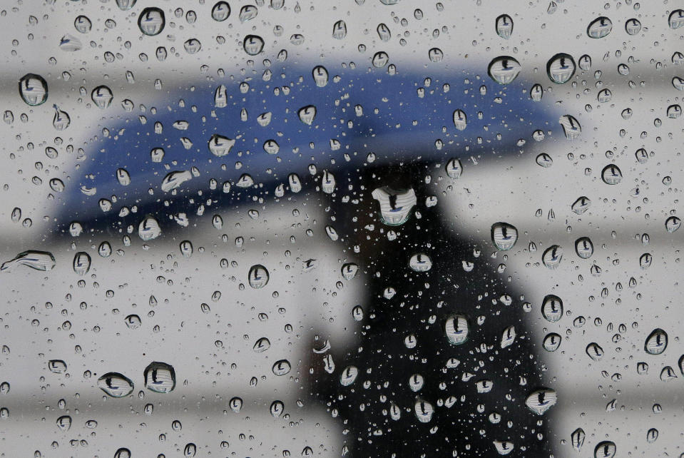 A man walks with an umbrella down California Street in San Francisco, Wednesday, Feb. 26, 2014. The storm is expected to move down the coast, dumping a half-inch to an inch in southern areas late in the day, forecasters said. (AP Photo/Jeff Chiu)