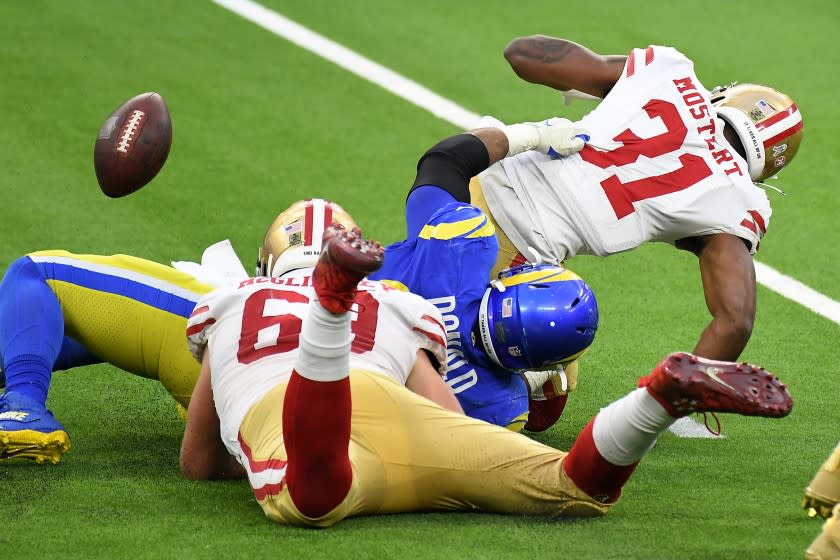 INGLEWOOD, CALIFORNIA NOVEMBER 29, 2020-Rams defensive lineman Aaron Donald forces a fumble as he tackles 49ers running back Raheem Mostert in the 3rd quarter at SoFi Stadium in Inglewood Sunday. The Rams recovered the ball for a touchdown. (Wally Skalij/Los Angeles Times)