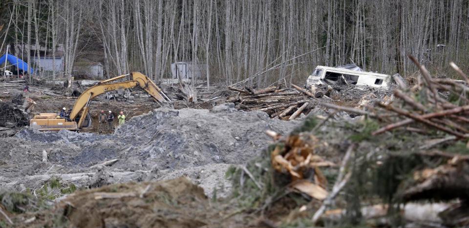 A demolished recreational vehicle lies in a debris field at the scene of a deadly mudslide nearly two weeks earlier nearby, Thursday, April 3, 2014, in Oso, Wash. More than a dozen people are listed as missing and 30 bodies have been found in debris from the March 22 landslide that broke off a steep hill, roared across the North Fork of the Stillaguamish River and buried a community at Oso, about 55 miles north of Seattle. (AP Photo/Elaine Thompson)