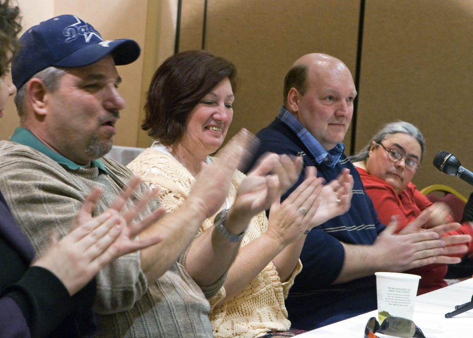 FILE - In this Jan 26, 2009 file photo, four of the six people known as the Beatrice Six, from left, James Dean, JoAnn Taylor, Thomas Winslow, and Debra Shelden, right, applaud during a reception in Lincoln, Neb. A Nebraska county that owes more than $30 million to six people wrongfully convicted of murder has approved a new half-cent sales tax to help pay the legal judgment, but the former prisoners will still have to wait at least six years to collect the full amount they’re owed. (AP Photo/Nati Harnik, File)