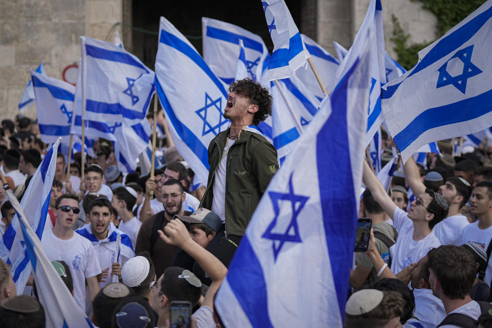 Israelis dance and wave national flags during a march marking Jerusalem Day, an Israeli holiday celebrating the capture of east Jerusalem in the 1967 Mideast war, in front of the Damascus Gate of Jerusalem's Old City, Thursday, May 18, 2023. (AP Photo/Ohad Zwigenberg)