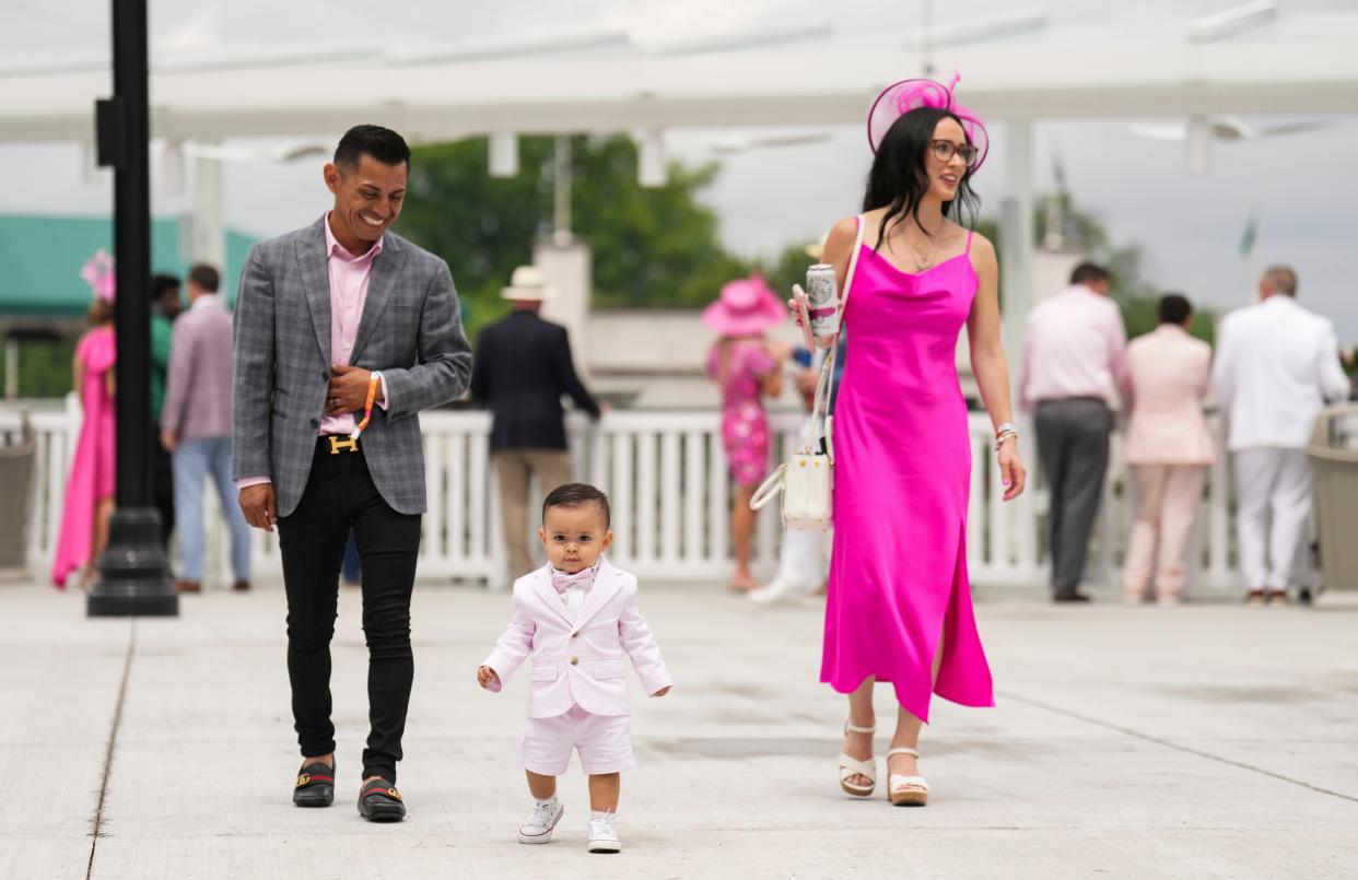 Jockey Abel Cedillo watches his one-year-old son Lukas run ahead as wife Sara looks on in the Paddock on Kentucky Oaks Friday, May 3, 2024 in Louisville, Kentucky.