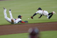 Atlanta Braves shortstop Adeimy Hechavarria, left, and second baseman Ozzie Albies dive for a ball hit for a single by Los Angeles Dodgers' Justin Turner inning of a baseball game Saturday, Aug. 17, 2019, in Atlanta. (AP Photo/John Bazemore)