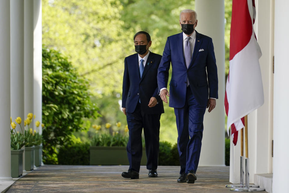 President Joe Biden, accompanied by Japanese Prime Minister Yoshihide Suga, walks from the Oval Office to speak at a news conference in the Rose Garden of the White House, Friday, April 16, 2021, in Washington. (AP Photo/Andrew Harnik)