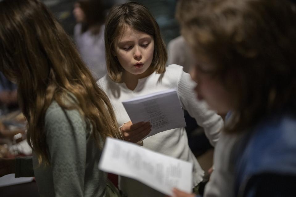 Members of the Polargospel, the children's choir at the only church in Svalbard, rehearse songs during their journey to Barentsburg, Norway, Saturday, Jan. 7, 2023. The choir traveled three hours each way by boat to mark Orthodox Christmas with the 40 children in Barentsburg, a village owned by Russia's Arctic mining company in the remote Norwegian territory. (AP Photo/Daniel Cole)