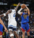 Denver Nuggets guard Jamal Murray, right, shoots over Minnesota Timberwolves guard Anthony Edwards, left, in the first half of Game 1 of an NBA basketball second-round playoff series Saturday, May 4, 2024, in Denver. (AP Photo/David Zalubowski)