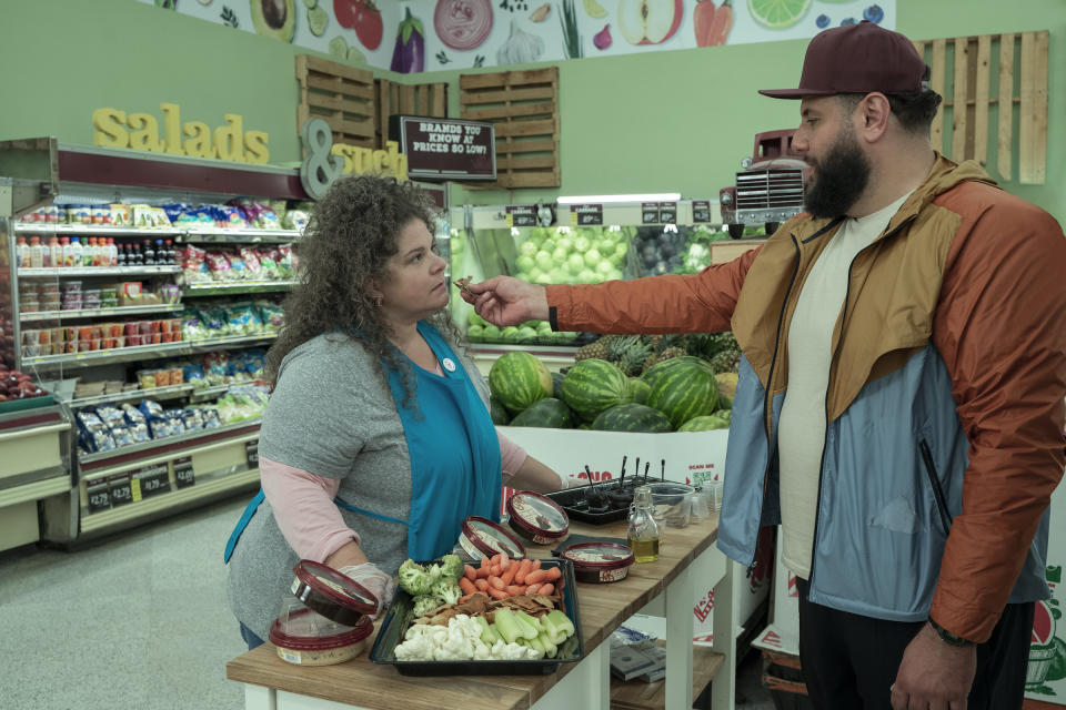 Mo feeds the grocery store worker a piece of pita dipped in his mother's homemade olive oil.<span class="copyright">Rebecca Brenneman—Netflix</span>