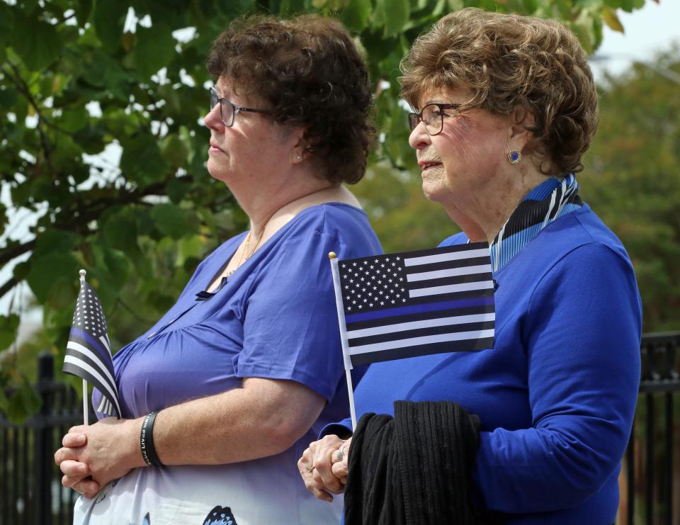 April Stearns and Judy Carr listen as the names of fallen officers are read aloud during a wreath laying ceremony held Friday morning, May 5, 2023, at the Fallen Heroes Memorial in Shelby.