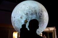 University of Colorado Boulder director of NASA/NLSI Lunar University Network for Astrophysics Research Burns points out locations on a lunar globe at the Fiske Planetarium