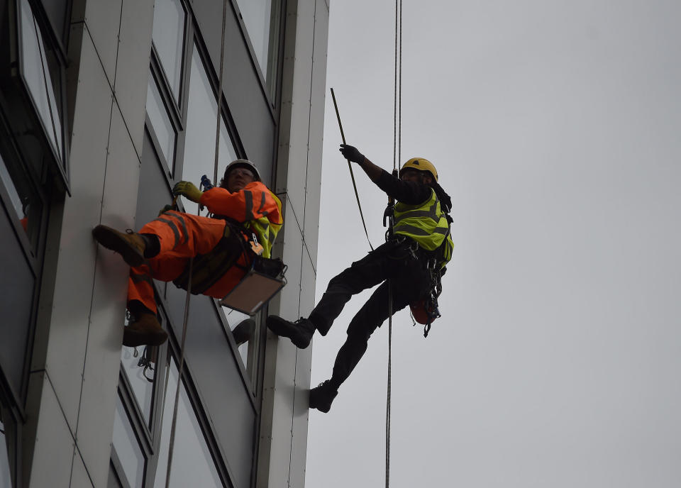 <p>Specialists abseil down the side of Bray Tower to check the cladding, on the Chalcots Estate in north London, Britain, June 27, 2017. (Photo: Hannah McKay/Reuters) </p>