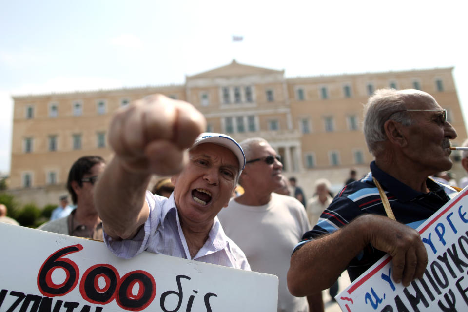 A Pensioner chants slogans outside the Greek parliament, seen behind, during a rally against healthcare cuts, in Athens, on Saturday, Sept. 8, 2012. Greece, in the grip of a severe recession for the fifth straight year, is still struggling to avoid bankruptcy by imposing harsh austerity measures, including wage and pension cuts, with unemployment increasing to nearly a quarter of the workforce.(AP Photo/Petros Giannakouris)