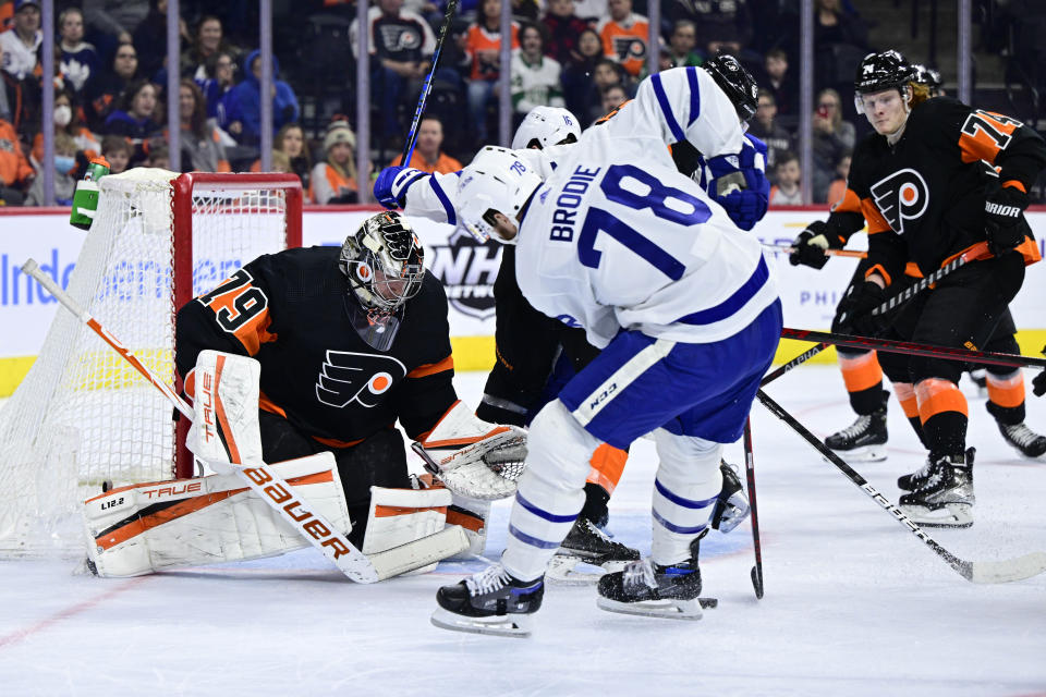 Philadelphia Flyers goaltender Carter Hart, left, makes a save on a shot from Toronto Maple Leafs defenseman TJ Brodie (78) during the first period of an NHL hockey game, Saturday, April 2, 2022, in Philadelphia. (AP Photo/Derik Hamilton)