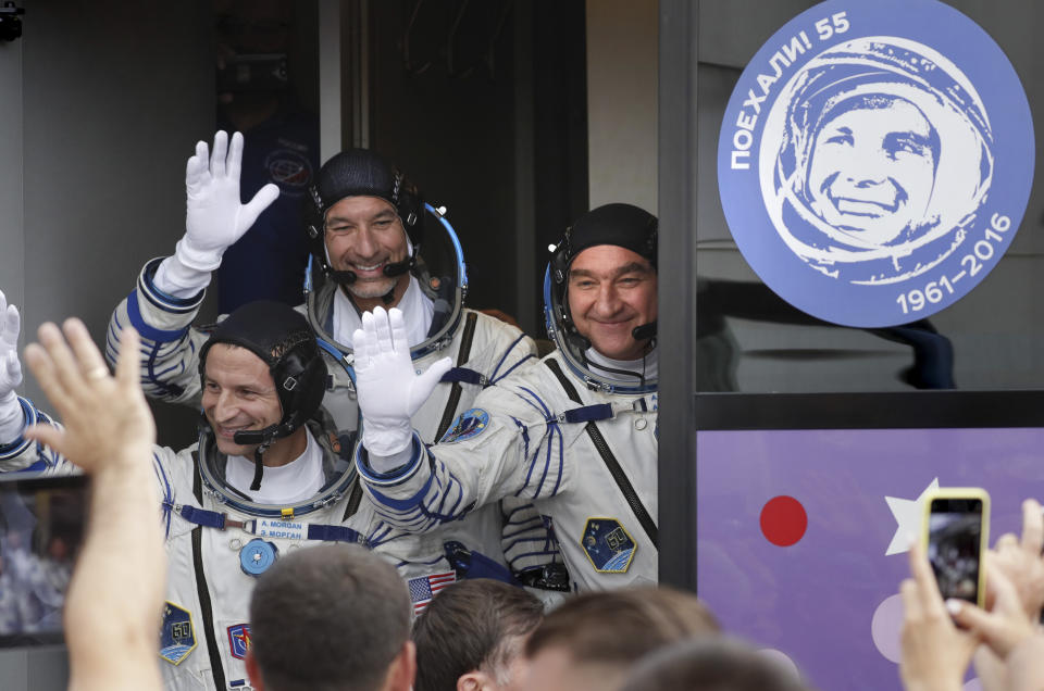 U.S. astronaut Andrew Morgan, Russian cosmonaut Alexander Skvortsov Italian astronaut Luca Parmitano, member of the main crew of the expedition to the International Space Station (ISS), wave to their relatives boarding to a bus prior the launch of Soyuz MS-13 space ship at the Russian leased Baikonur cosmodrome, Kazakhstan, Saturday, July 20, 2019. (AP Photo/Yuri Kochetkov, Pool)