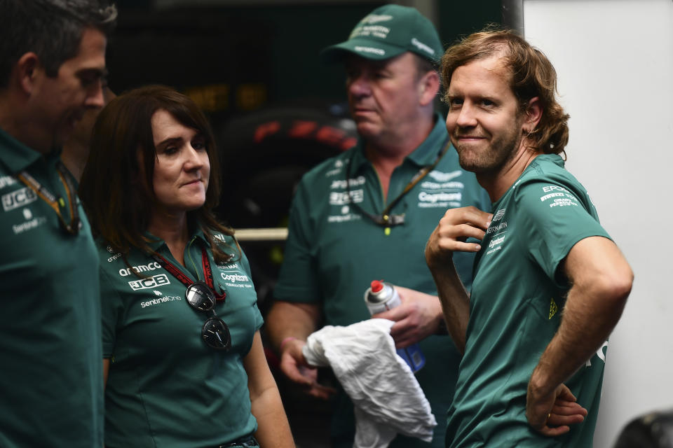 Aston Martin driver Sebastian Vettel of Germany is surrounded with members of his team at the Hungaroring racetrack in Mogyorod, near Budapest, Hungary, Thursday, July 28, 2022. Four-time Formula One champion Sebastian Vettel says he will retire at the end of the season to spend more time with his family. The Hungarian Formula One Grand Prix will be held on Sunday. (AP Photo/Anna Szilagyi)