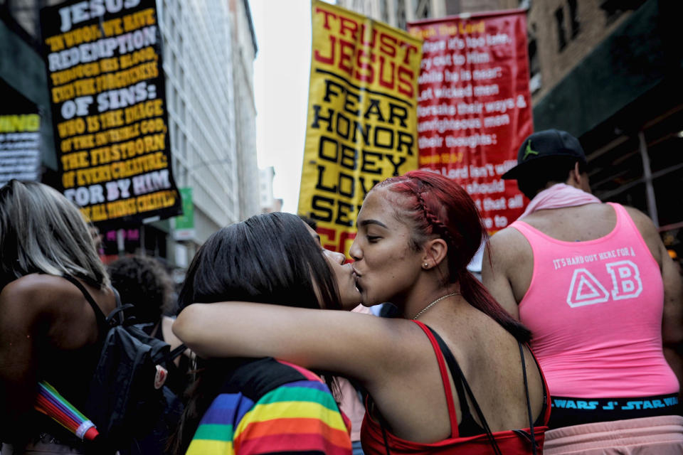 Parade-goers kiss in front of a counter-protest to the Gay Pride parade in New York on Sunday, June 30, 2019. (AP Photo/Wong Maye-E)