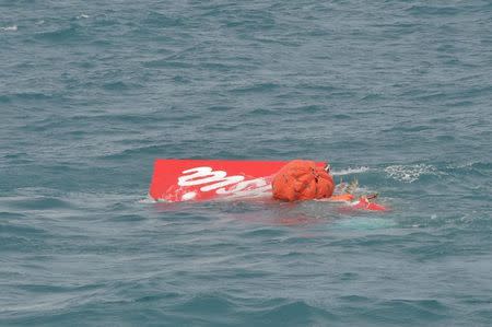 Part of the tail of AirAsia QZ8501 floats on the surface after being lifted as Indonesian navy divers conduct search operations for the black box flight recorders and passengers and crew of the aircraft, in the Java Sea January 10, 2015. REUTERS/Adek Berry/Pool