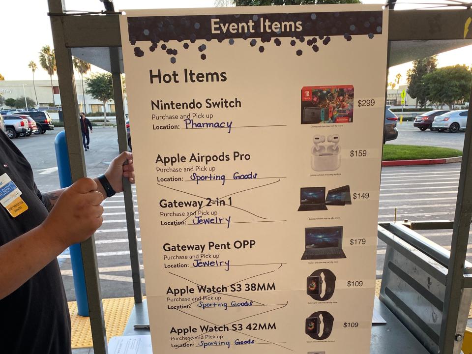 A Walmart deals cart outside the store showing "Hot Items" on sale