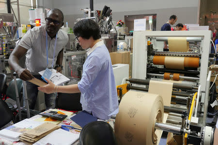 A visitor checks a high speed paper bag making machine displayed at the China Import and Export Fair in Guangzhou, China April 17, 2017. REUTERS/Venus Wu