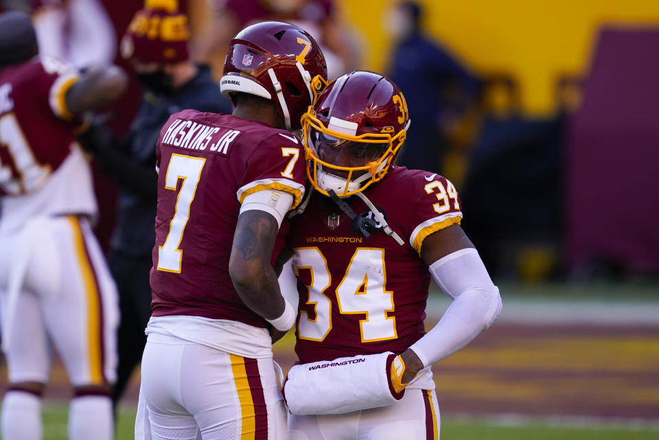 Washington Football Team quarterback Dwayne Haskins (7) greeting teammate running back Peyton Barber (34) before the start of an NFL football game against the Carolina Panthers, Sunday, Dec. 27, 2020, in Landover, Md. (AP Photo/Mark Tenally)