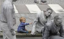 <p>A small boy touches a participants of the performance ‘1000 GESTALTEN’ with hundreds of people painted like clay figures moving slowly and silently through the streets of Hamburg to protest against the G-20 summit in Hamburg, northern Germany, July 5, 2017. (Matthias Schrader/AP) </p>