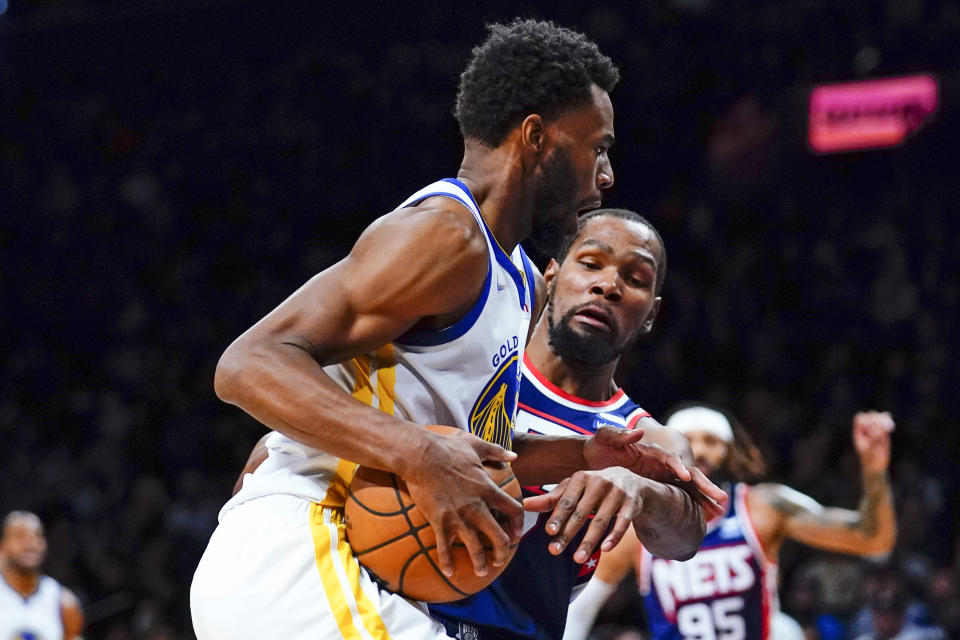 Brooklyn Nets' Kevin Durant, right, reaches in for the ball against Golden State Warriors' Andrew Wiggins (22) during the first half of an NBA basketball game Tuesday, Nov. 16, 2021 in New York. (AP Photo/Frank Franklin II)